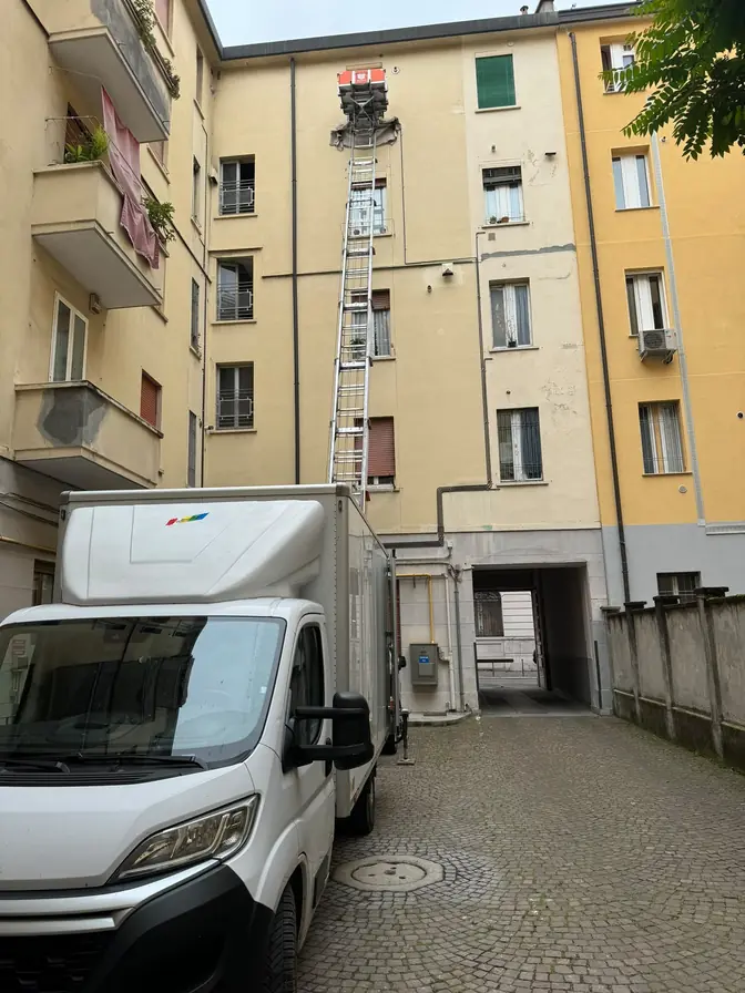 Furgone ed elevatore esterno nel cortile di un edificio